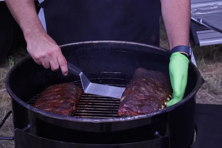 a person cooking meat on a grill