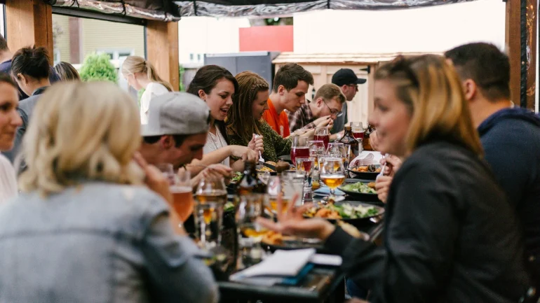 a group of people sitting at a table eating food