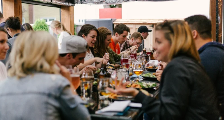 a group of people sitting at a table eating food